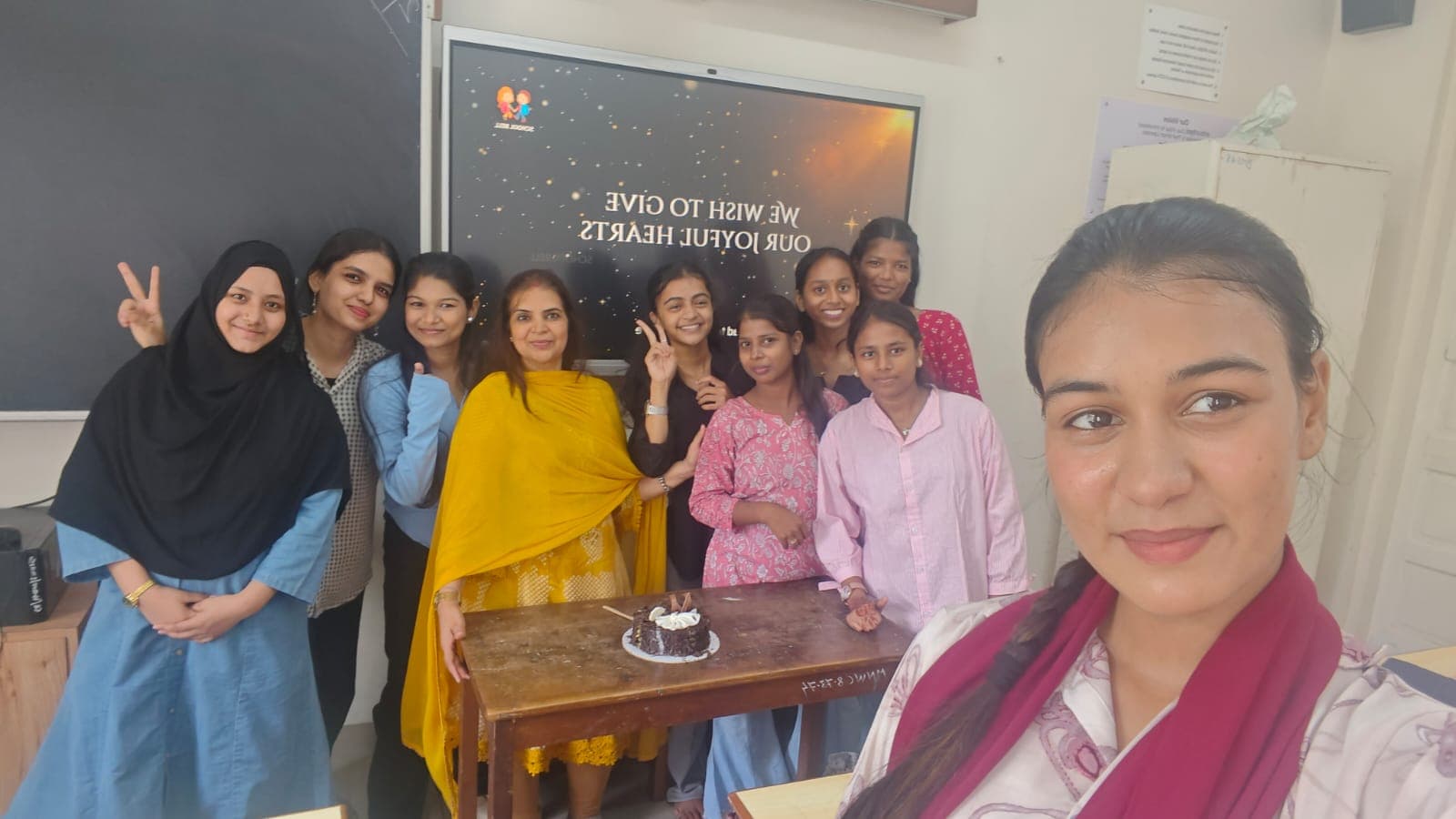 Paramedical students gather in a classroom around a cake after a session.